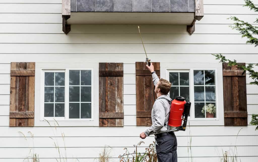 A man carrying pest control equipment